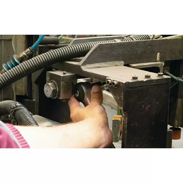 Mob Umschaltknarre - Antriebsgröße: ½″ - Hand bedient ein Werkzeug an einer Industriemaschine.
