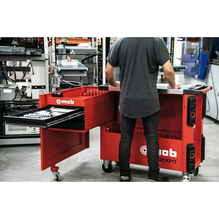 Mob Werkstattwagen - Anzahl Schubladen: 3 Stk. - Eine Person benutzt eine rote mobile Werkbank mit geöffneter Schublade voller Werkzeuge in einer Werkstatt. Sie hat Steckdosen und Räder.