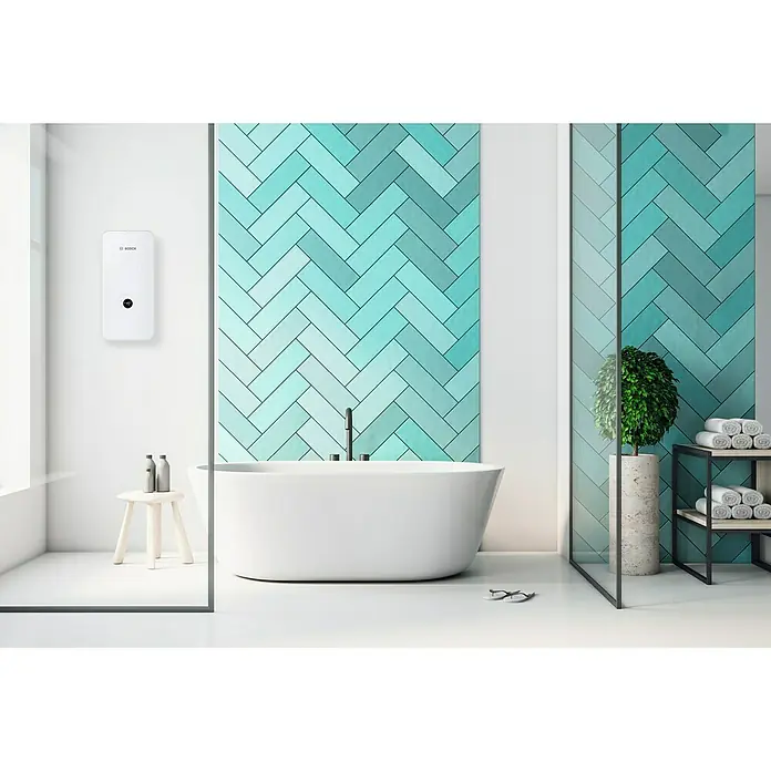 Bosch Durchlauferhitzer Tronic Advanced AquaStop - 21/24/27 kW, Elektronisch - Ein modernes Badezimmer mit einem Bosch-Warmwasserbereiter an der Wand, einer freistehenden Badewanne und blaugrünen Fliesen.