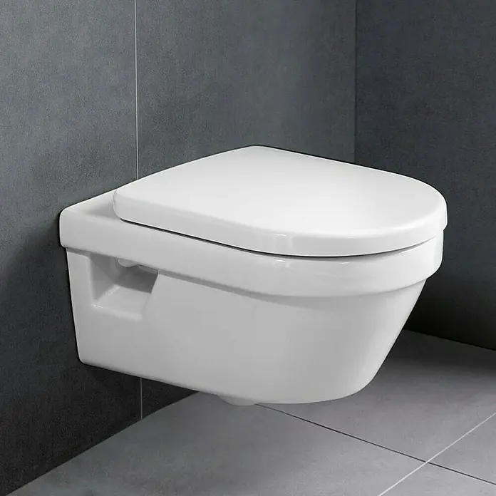 Villeroy & Boch Architectura Wand-WC 2 - Spülrandlos, Mit schmutzabweisender Glasur, Spülform: Tief, WC Abgang: Waagerecht, Weiß - Eine wandhängende Toilette in Weiß vor einer grauen Wand und Fliesen. Das minimalistische Design des WCs ist modern und platzsparend.