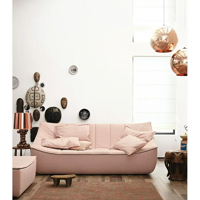 SCHÖNER WOHNEN-Farbe Wandfarbe TrendfarbeWool, Matt, 5 l, Konservierungsmittelfrei - Ein stilvolles Interieur mit einem rosa Sofa als zentralem Element, ergänzt durch dekorative Elemente an der Wand und modernen Lampen.