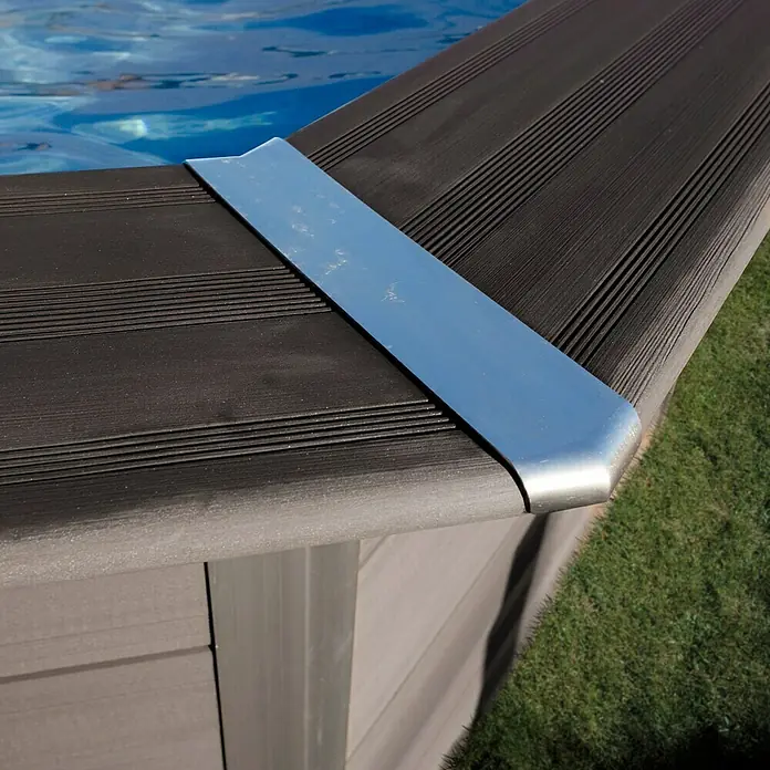 Gre Avantgarde WPC-Pool - L x B x H: 524 x 386 x 124 cm, 16.210 l, Dunkelgrau - Nahaufnahme eines Poolrandes mit einer silbernen Eckabdeckung, die Schutz und ein elegantes Finish bietet. Der Pool ist mit klarem, blauem Wasser gefüllt.