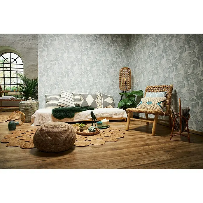 A.S. Création New Walls Vliestapete Dschungel - Grün/Weiß, Floral, 10,05 x 0,53 m - Einladendes Wohnzimmer mit Rattanmöbeln, Pouf und Kissen auf einer niedrigen Couch. Ein exotisches Ambiente durch das florale Tapetenmuster.