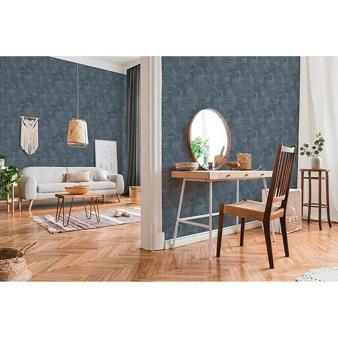 A.S. Création New Walls Vliestapete Dschungel - Blau/Grau, Floral, 10,05 x 0,53 m - Einladendes Interieur mit blauer Tapete mit Blattmuster, ergänzt durch ein Sofa, einen Tisch und einen Schreibtisch mit Spiegel für einen stilvollen Look.
