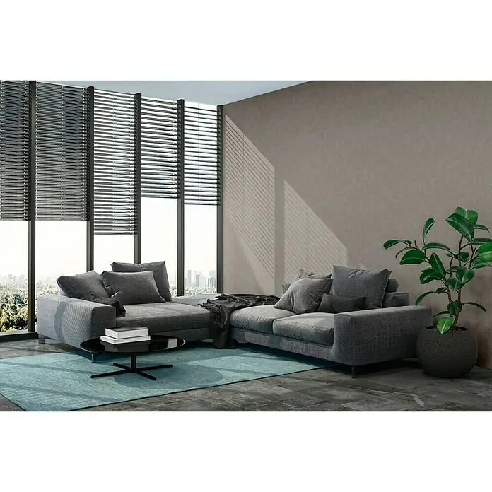 A.S. Création New Walls Vliestapete Beton - Taupe, Betonoptik, 10,05 x 0,53 m - Elegante graue Wohnlandschaft mit stilvollem Couchtisch und Zimmerpflanze vor Fensterfront mit Jalousien, die eine moderne Atmosphäre schafft.