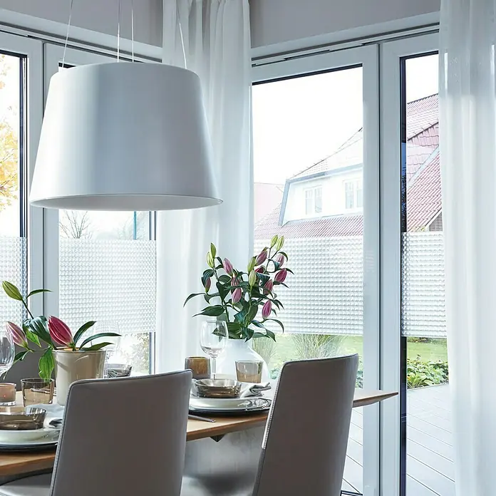 D-c-fix StaticStripes Glasfolie Milton - 200 x 45 cm, Transluzent, Statisch haftend - Helle Inneneinrichtung mit einer eleganten Pendelleuchte über einem Esstisch, der mit Geschirr und Blumen dekoriert ist. Moderne Fenster mit stilvollen Rollos.