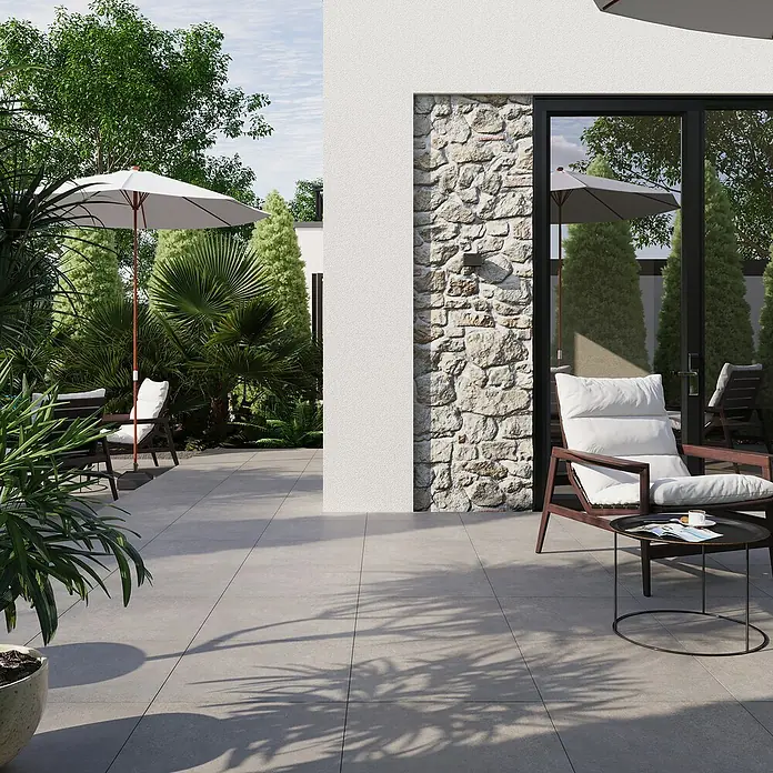 Terrassenfliese Beton - 60 x 60 x 2 cm, Dunkelgrau, Matt - Elegantes Terrassenbild mit stilvollen Fliesen, bequemen Möbeln und üppigem Grün. Die Fliesen harmonieren perfekt mit der Natur.