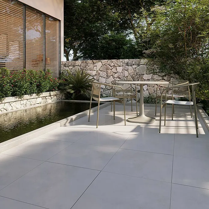 Terrassenfliese Modena - 60 x 60 x 2 cm, Dusty/Grau, Matt - Ein einladender Außenbereich mit einem eleganten runden Tisch und vier passenden Stühlen, ideal für entspannte Stunden im Freien.