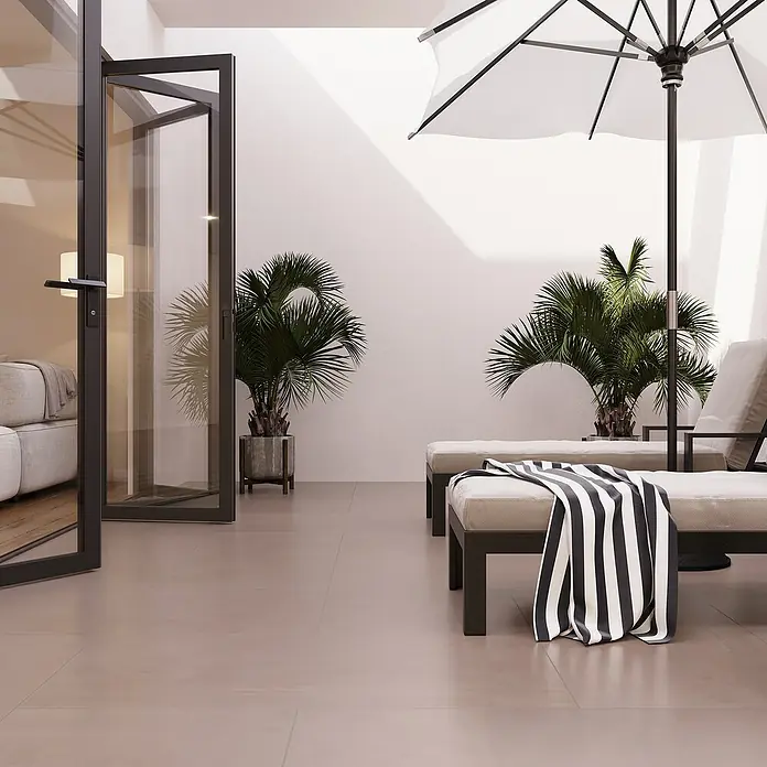 Terrassenfliese Modena - 60 x 120 x 2 cm, Mud/Beigegrau, Matt - Elegante Terrassengestaltung mit bequemen Liegen unter einem Sonnenschirm und üppigen Topfpflanzen, die eine entspannende Atmosphäre schaffen.
