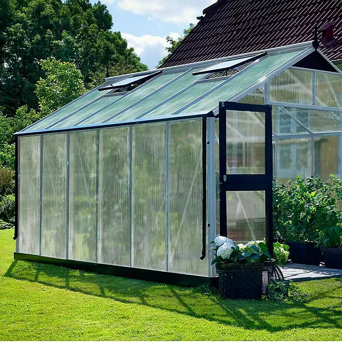 Juliana Gewächshaus Premium - Außenmaß inkl. Dachüberstand (B x T): 296 x 439 cm, Material Seitenwand: Kunststoff, 10 mm, Silber/Schwarz - Ein Gewächshaus mit durchsichtigen Wänden und einem schwarzen Rahmen steht im Garten und ermöglicht kontrolliertes Pflanzenwachstum.