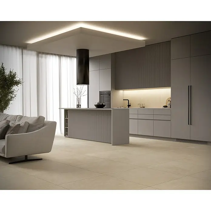 Feinsteinzeugfliese Giant - 79,7 x 79,7 cm, Beige, Matt - Elegantes Küchendesign mit grauem Sofa, Kücheninsel und modernen Geräten für ein stilvolles Wohnambiente.
