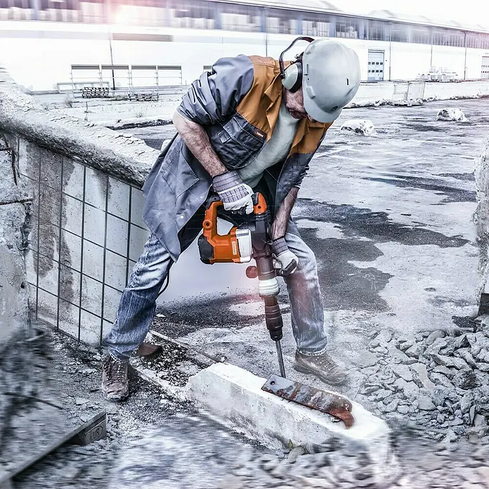 Toolson Abbruchhammer PRO-HM 27 MAX - 1.500 W, 32 J, SDS-Max-Aufnahme - Ein Bauarbeiter mit einem Presslufthammer bei der Arbeit. Der Hammer wird zum Aufbrechen von Beton verwendet.