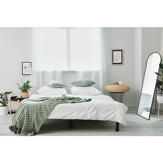 Standspiegel Elina - 40 x 160 cm, Schwarz, Metall - Einladendes Schlafzimmer mit einem bequemen Bett, dekoriert mit Kissen und einer grünen Tagesdecke. Spiegel und Pflanzen ergänzen den Raum.