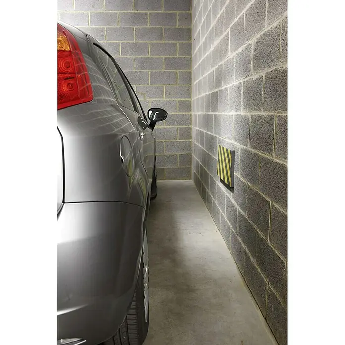 Mottez Schutzmatte - Geeignet für: Fahrzeuge, L x B x H: 50 x 25 x 2,5 cm - Eine Nahaufnahme eines Autos, das in einer Garage geparkt ist, wobei der Fokus auf der Rückseite des Fahrzeugs und der Wand mit einem Warnschild liegt.