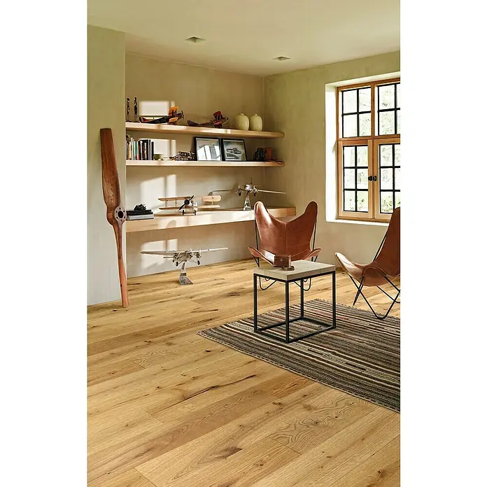 Parador Parkettmuster Classic 3060 Rustikal Eiche - 200 x 185 x 13 mm, Landhausdiele - Einladendes Wohnzimmer mit hellem Holzboden, zwei Ledersesseln und einem Beistelltisch auf einem gestreiften Teppich.