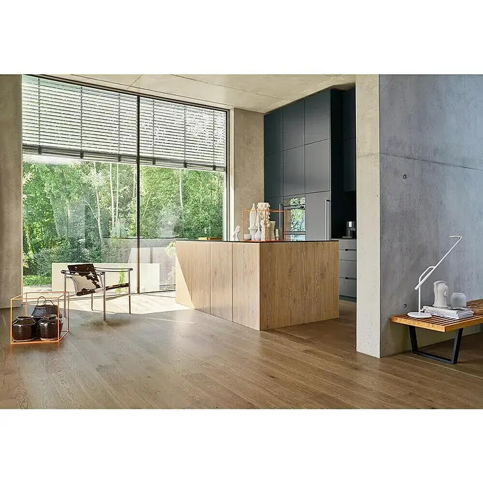 Parador Parkett Trendtime 4 - Eiche nougat, Landhausdiele, 2.010 x 160 x 13 mm - Moderne Küche mit einer Kochinsel aus Holz und einem großen Fenster mit Blick auf den Garten, kombiniert mit modernen grauen Schränken.