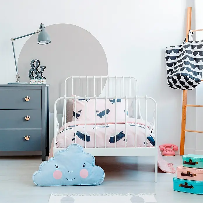 Vinilo de pared Círculo - Gris neutro, Plástico - Habitación infantil con una cuna blanca, una cómoda gris y un cojín de nube azul. El juego de cama es rosa con motivos de ballenas.