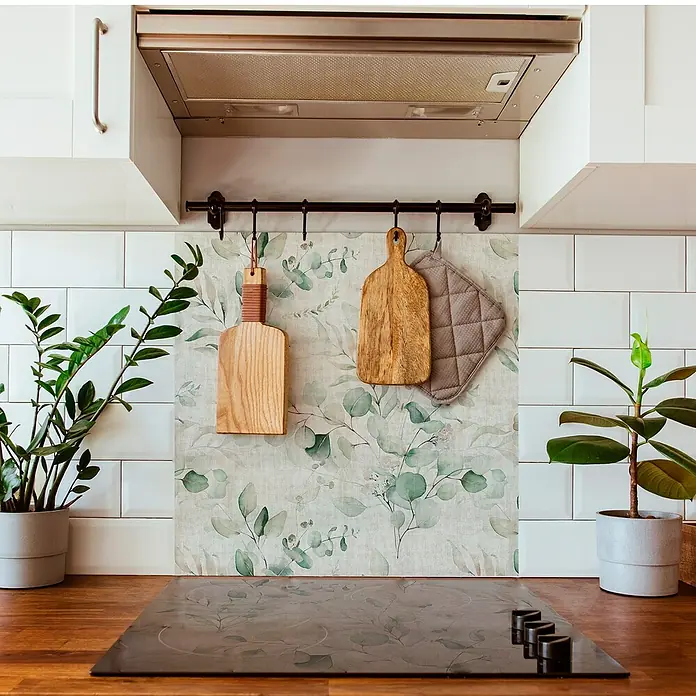 Panel de pared salpicadero de cocina Eucalipto - L x An: 60 x 60 cm - Revestimiento posterior de cocina con diseño de eucalipto que complementa la placa de cocción y las tablas de cortar de madera colgadas en la barra.