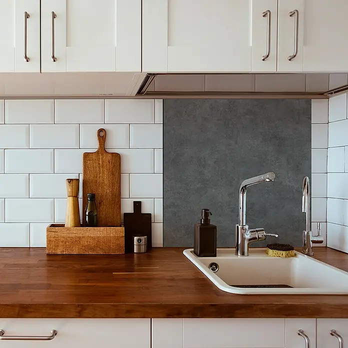 Panel de pared salpicadero de cocina Concret - L x An: 60 x 60 cm - Área del fregadero con encimera de madera, armarios blancos y utensilios como tablas de cortar y jabón.