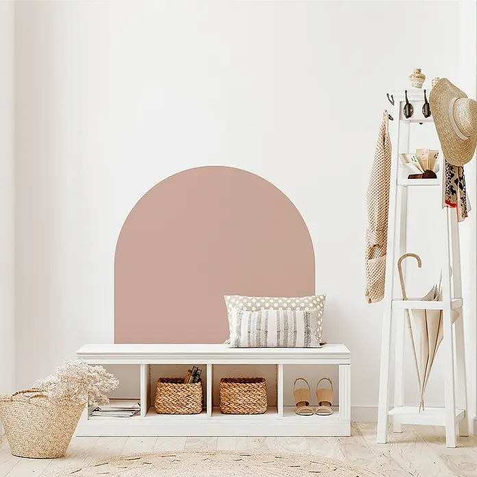 Vinilo de pared autoadhesivo Arco Rosa Empolvado - 110 x 132 cm, Rosa, Plástico - Esta imagen muestra una elegante configuración de entrada con un banco, una calcomanía de pared en forma de arco y un perchero blanco que proporciona un ambiente acogedor.