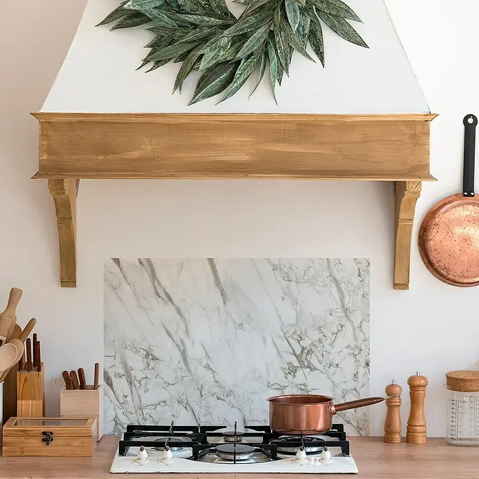 Panel de pared salpicadero de cocina Marble - L x An: 90 x 60 cm, Café - La cocina cuenta con una olla de cobre, colocada contra un protector de mármol. Utensilios de cocina y especias completan la escena.