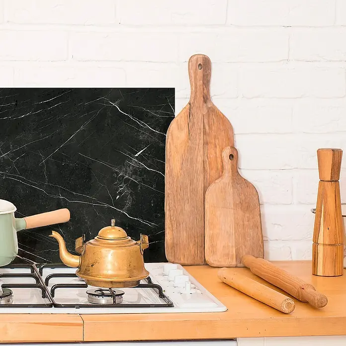 Panel de pared salpicadero de cocina Marquina - L x An: 60 x 60 cm - Decoración de cocina con tablas de cortar, tetera, olla y panel de mármol sobre una pared de ladrillo blanco.