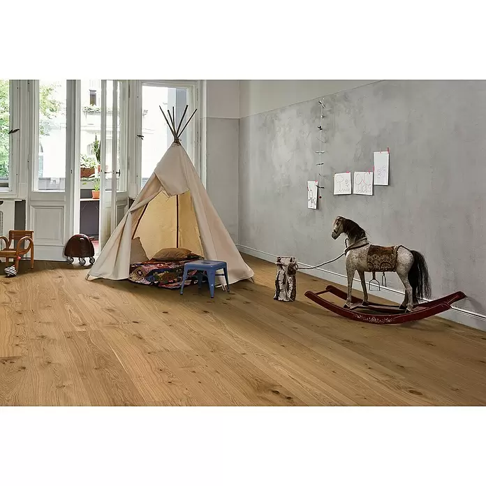 Parador Parkett Basic 11.5 - Rustikal Eiche, Landhausdiele, 2.380 x 233 x 11,5 mm - Heller Holzboden mit natürlicher Maserung, verlegt in einem Kinderzimmer mit Spielzelt und Schaukelpferd.