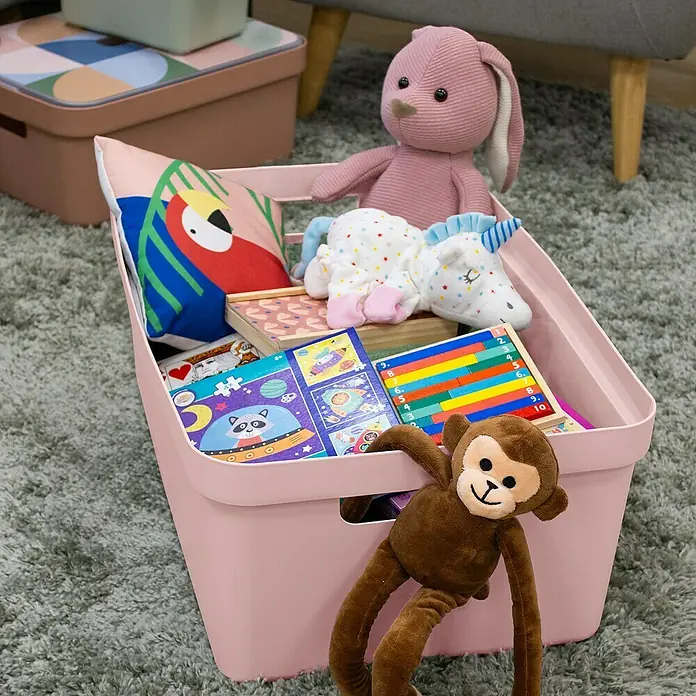 Sunware Sigma home Aufbewahrungsbox - L x B x H: 59 x 39 x 24,2 cm, Kunststoff, Rosa - Ein rosa Spielzeugbehälter gefüllt mit Stofftieren, Büchern und Spielzeug auf einem Teppich.