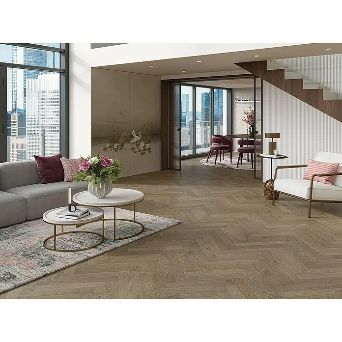 Parador Parkettmuster Trendtime 3 Living Plus Eiche Chalet grau - 200 x 95 x 13 mm, Fischgrät - Wohnzimmer mit Parkettboden, grauer Couch, Couchtischen und Blick auf die Stadt, der den einladenden Raum hervorhebt.