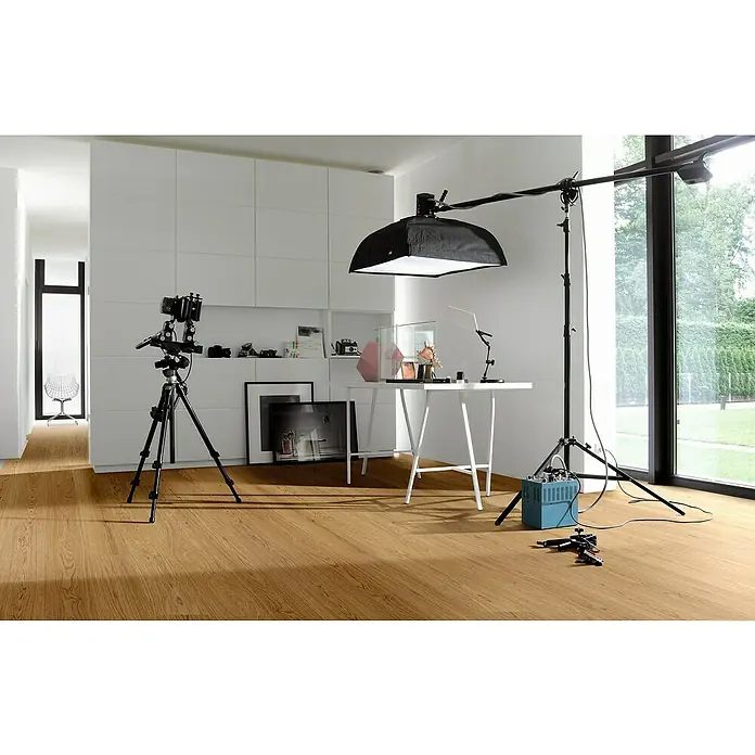 Parador Parkett Classic 3025 - Classic Eiche gebürstet, Landhausdiele, 2.200 x 185 x 13 mm - Ein heller Raum mit einem Holzfußboden, in dem ein Fotostudio aufgebaut ist, mit Stativen, Lichtern und einer Kamera für professionelle Aufnahmen.