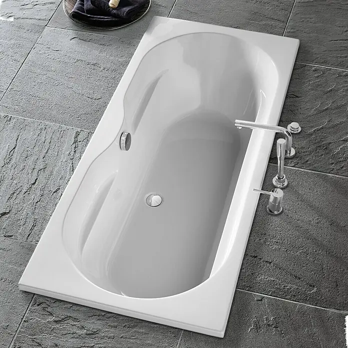 Camargue Montpellier Badewanne - 170 x 75 cm, Sanitäracryl, Weiß - Weißer Badewannen-Einbau mit glänzenden Chromarmaturen auf grauem Fliesenboden. Das moderne Design verleiht jedem Badezimmer einen Hauch von Eleganz.