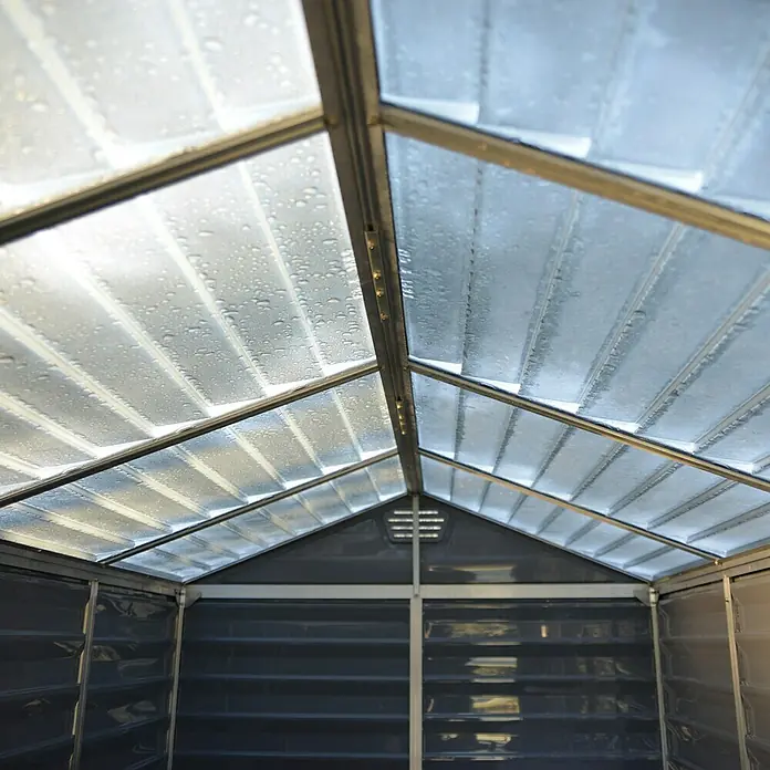 Palram – Canopia Gartenhaus Skylight 6x8 - Außenmaß inkl. Dachüberstand (B x T): 185 x 229 cm, Kunststoff, Anthrazit/Grau - Innenansicht eines Gerätehauses mit transparentem Dach und Metallrahmen, der einen Blick auf das Innere mit horizontalen Regalen und grauen Wänden bietet.