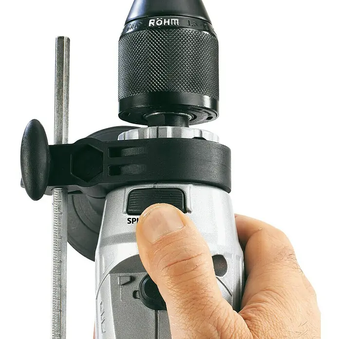 Einhell Taladro percutor TE-ID 650 E - 650 W, 3.000 r.p.m., Número máx. de impactos: 48.000 /min - Primer plano de un taladro de columna con portabrocas Röhm en acción, con un dedo accionando un interruptor. Ideal para aficionados y profesionales.