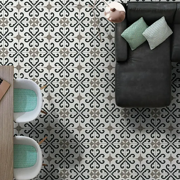 Halcón Pavimento porcelánico hidráulico Derby - 45 x 45 cm, Blanco/Negro/Marrón, Mate, Rectificado, 7 ud. - Vista superior de una habitación con baldosas de cemento estampadas, un sofá de cuero y sillas blancas.