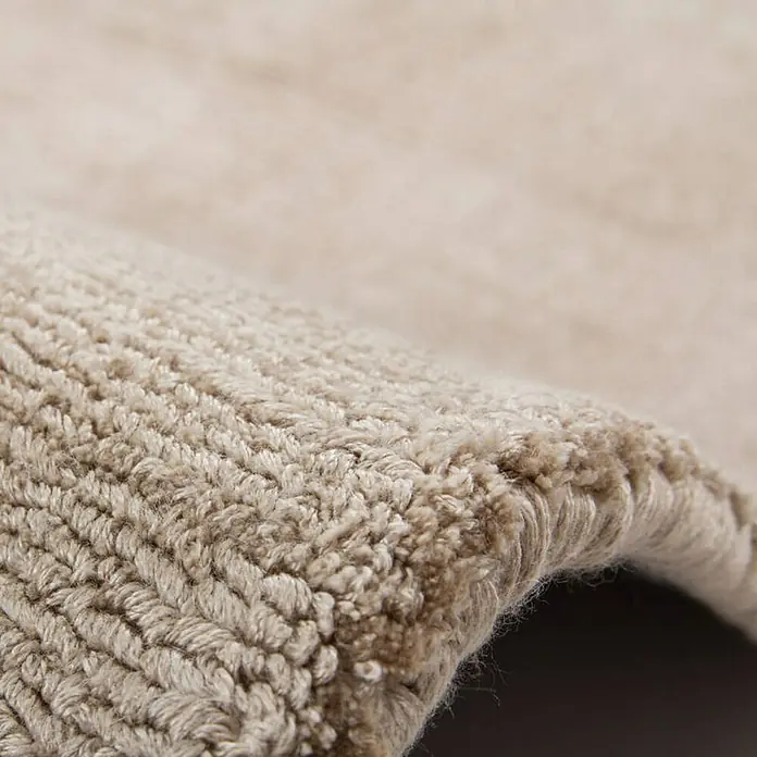 Kayoom Kurzflorteppich Luxury - Elfenbein/Taupe, 150 x 80 cm, 100 % Viskose - Nahaufnahme eines beigefarbenen Teppichs, der die Textur und die gewebten Details des Materials hervorhebt. Ideal für Wohnaccessoires.