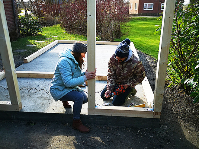 Ein Mann und eine Frau beim Gartenhaus aus Holz selber bauen