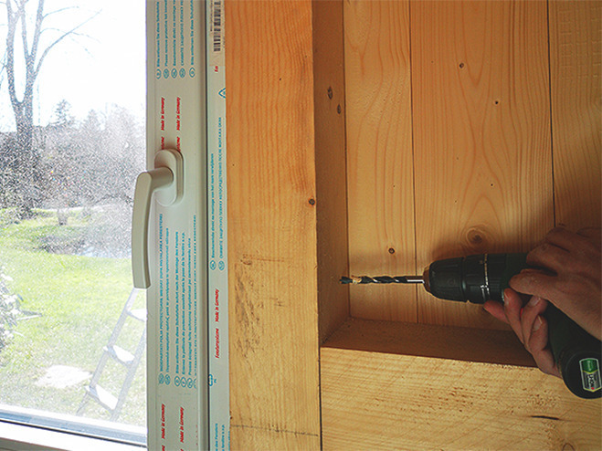 Festschrauben der Fenster beim Gartenhaus aus Holz bauen