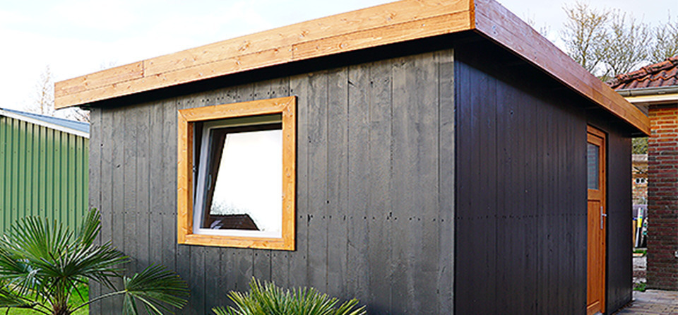 Selbst gebautes Holz-Gartenhaus mit schwarzem Anstrich