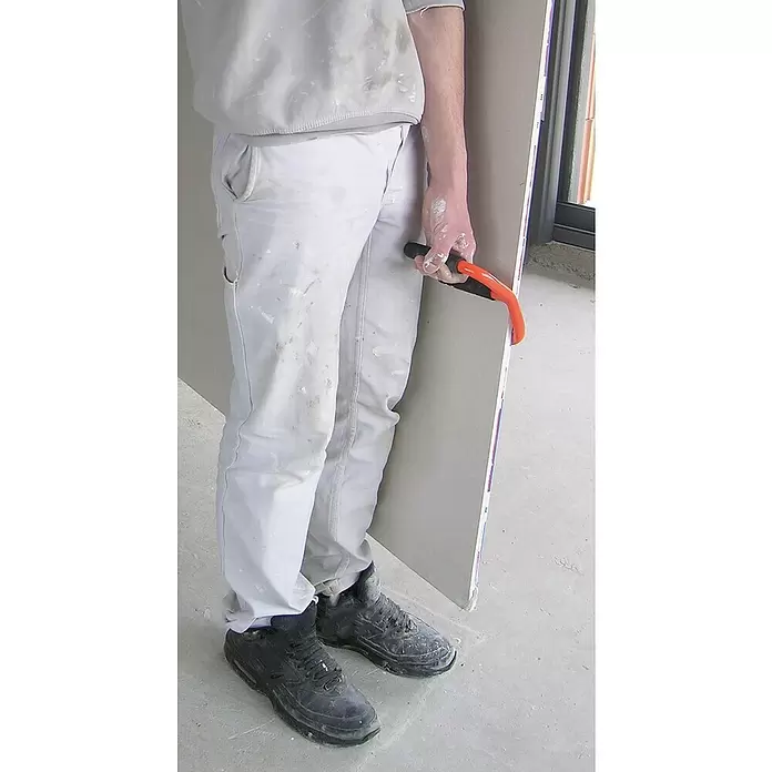 Mondelin Plattenheber - Orange, Geeignet für: Gipskartonplatten - Person trägt eine Gipskartonplatte mit einem orange-schwarzen Hebegriff.