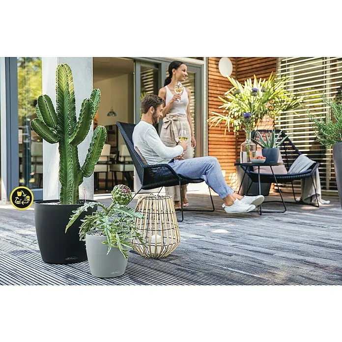 Lechuza Classico Pflanztopf Eco - Außenmaß (Ø x H): 27,5 x 26 cm, Kunststoff, Dunkelgrau - Entspannende Szene auf einer Terrasse mit stilvollen LECHUZA Pflanzgefäßen, die eine moderne und einladende Atmosphäre schaffen.