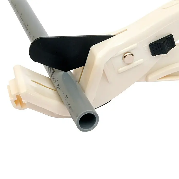 Cortatubos polibutileno - 15 mm - 28 mm - Primer plano de un cortatubos de PVC en acción, cortando un tubo de plástico gris. Una herramienta útil para cortes precisos en proyectos de fontanería.