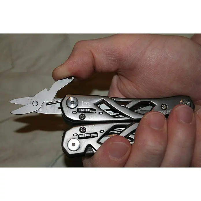 Gerber Alicates multiuso plegable Suspension - Acero inoxidable - Una multiherramienta Gerber de color plateado sostenida en una mano con las tijeras extendidas.