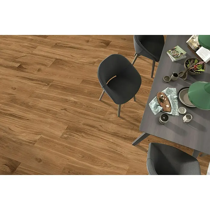 Pavimento porcelánico Selva - 22,5 x 119,5 cm, Teka, Rectificado - Acogedora zona de comedor con suelo de madera y mesa gris, creando un ambiente cálido y moderno.