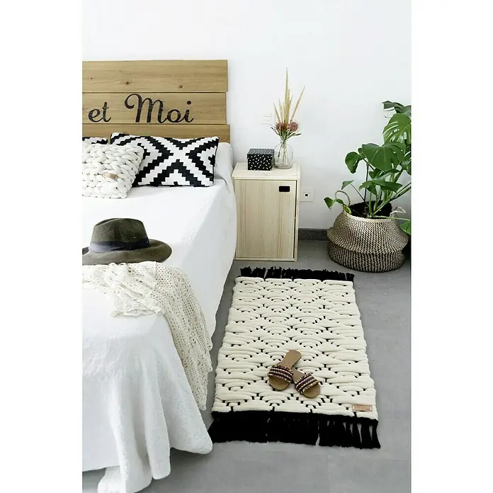 Astigarraga Dinamic Schrank - L x B x H: 33 x 37,3 x 53,5 cm, Kiefernholz - Blick auf einen dicken, handgefertigten, cremefarbenen Teppich mit schwarzen Fransen in einem Schlafzimmer, der Textur und Wärme ausstrahlt.