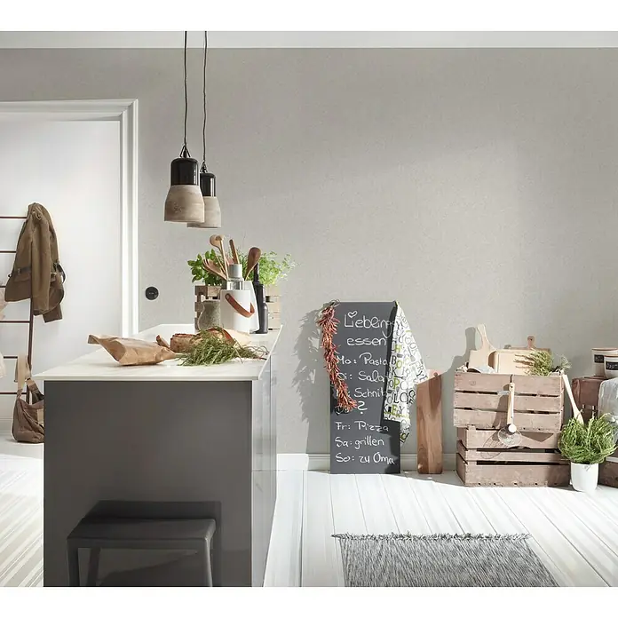 A.S. Création Vliestapete Putzstruktur - Taupe, Uni, 10,05 x 0,53 m - Eine stilvolle Küchenszene mit Pendelleuchten, einer Kücheninsel, einer Tafel mit Speiseplan und dekorativen Holzkisten.