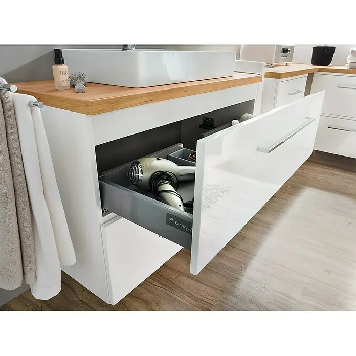Camargue Espacio Waschtischunterschrank100 x 46 x 60 cm, 2 Schubkästen, Mira - Ein Waschtischunterschrank mit Auszug zeigt einen Fön und Zubehör. Praktische Badmöbel für mehr Ordnung und Komfort im Badezimmer.