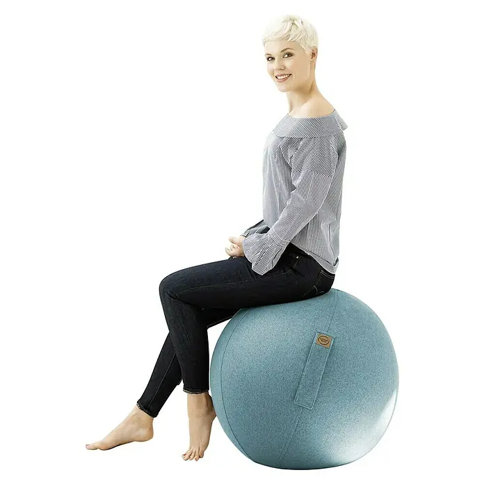 Sitting Ball Gymnastikball Felt - Aquarius, Durchmesser: 65 cm, 100 % Polyester - Frau sitzt auf einem hellblauen Sitzball mit praktischem Tragegriff, ideal für Büro und Zuhause, zur Förderung einer gesunden Körperhaltung.