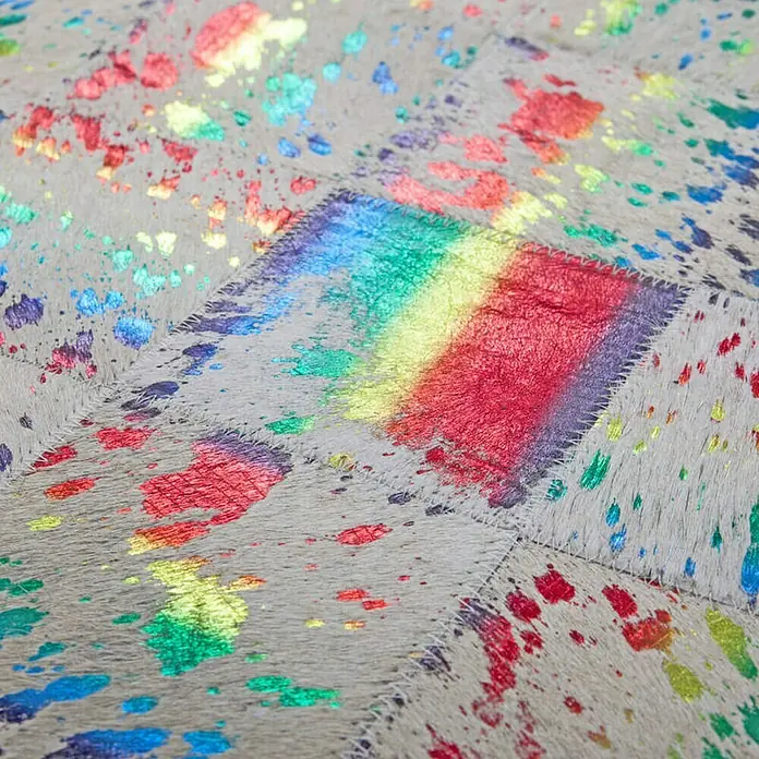 Kayoom Lederteppich Rocket - Multi, 230 x 160 cm, 100 % Leder - Nahaufnahme eines bunten Teppichs mit Regenbogenmuster und Farbtupfern. Ein echter Hingucker für jeden Raum.