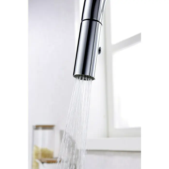Imex Grifo de cocina extraíble Samoa - Cromo - Primer plano de un grifo cromado con agua corriente, sobre un fondo luminoso y lleno de luz.