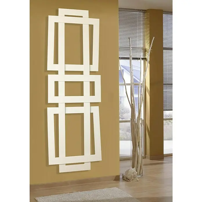 Szagato Designheizkörper Art II - B x H: 600 x 1.800 mm, Wärmeleistung bei Vorlauftemperatur von 75 °C (D: 50): 1.019 W, Weiß - Ein modernes Zimmer mit einem auffälligen, weißem Designheizkörper an der Wand, der ein einzigartiges geometrisches Muster aufweist.